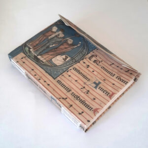 A notebook with visible hand stitching on the spine, covered in a faux medieval manuscript fragment cover.