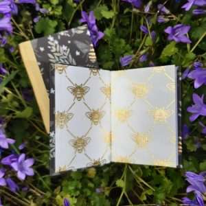 Two bee themes books with coloured book cloth spines and gold and white patterned endpapers.