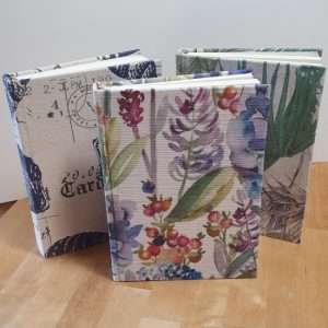 Three books each covered with a different fabric.